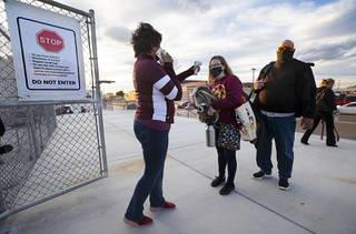 Kristen and Hilary Gavenda have their temperature checked at the gate to Trojan Field before a high school football game between the Moapa Valley Pirates and the Pahrump Valley Trojans in Pahrump Friday, March 19, 2021. Currently, only parents or legal guardians are allowed to attend the games.