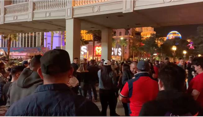 Visitors dance to music played by a Mexican band at the corner of Las Vegas Boulevard and Flamingo Road, Jan 19, 2019. Aided by NCAA viewing events, Las Vegas Strip packed with visitors to bring a sense of normalcy in slow reopening after nearly one year of COVID closures.