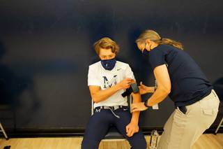 Senior student-athlete Mick Corrigan is fixed with a noninvasive COVID-19 screening device by Kim Jacobs, head athletic trainer for The Meadows School, before their football game against Lake Mead Academy, Friday March 26, 2021.