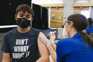 Duran Heath, 24, gets the COVID-19 vaccine at UNLV on April 5, 2021. Beginning Friday, Gov. Steve Sisolak is mandating that all people, regardless of vaccination status, wear masks in most public, indoor places in Clark County.