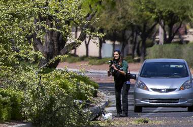 A Metro Police crime scene analyst takes photos after a fatal accident on Lake Mead Boulevard near Rampart Boulevard in Summerlin Wednesday, April 14, 2021.