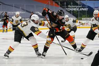Vegas Golden Knights defenseman Alec Martinez, left, tries to steal the puck from Anaheim Ducks center Sam Steel during the second period of an NHL hockey game Friday, April 16, 2021, in Anaheim, Calif.
