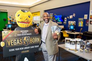 Clark County Library District executive director Kelvin Watson poses for a photo with their new Vegas Golden Knights bookmarks, Thursday April 29, 2021.
