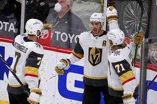 Vegas Golden Knights right wing Reilly Smith (19) is congratulated by defenseman Alex Pietrangelo (7) and center William Karlsson (71) after scoring a goal against the Minnesota Wild during the third period of an NHL hockey game Wednesday, May 5, 2021, in St. Paul, Minn. The Golden Knights won 3-2 in overtime.