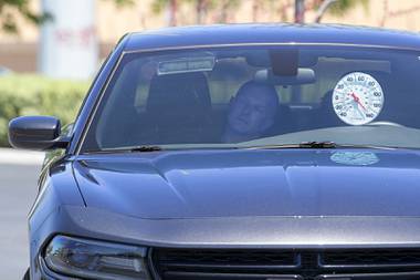 Metro Police Officer Larry Hadfield waits in a car with the windows up and the engine off during a news conference at Metro Police headquarters Thursday, May 13, 2021. The temperature in the car went from 85 degrees Fahrenheit to over 130 degrees in about 10 minutes.