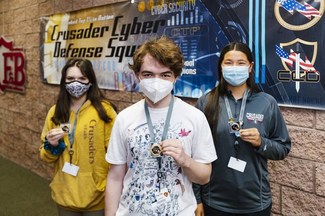 From left, students of the CyberPatriot cyber education program Natalie McKinney, Owen Thompson and Emma Kwok hold award medallions from CyberPatriot competitions at Faith Lutheran High School, Friday, May 14, 2021.