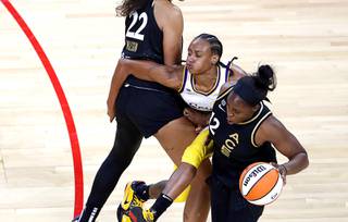 Los Angeles Sparks guard Brittney Sykes (15) is caught between Las Vegas Aces forward A'ja Wilson (22) and guard Chelsea Gray (12) during the Aces' home opener at the Mandalay Bay Events Center Friday, May 21, 2021.