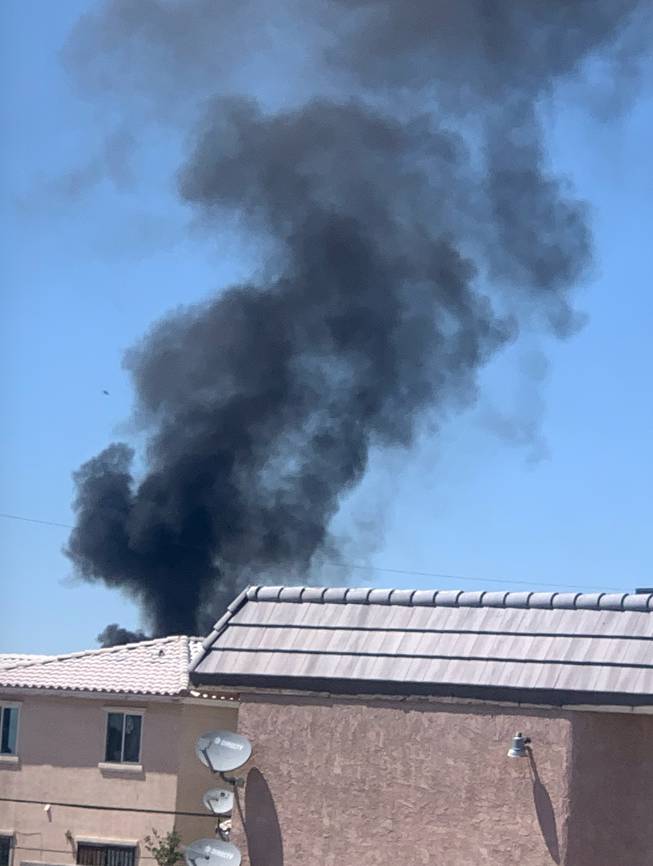 Smoke is visible in a northeast Las Vegas residential neighborhood where a military aircraft from Nellis Air Force Base crashed May 24, 2021.