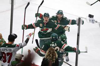 Minnesota Wild left wing Kevin Fiala (22) is congratulated by Joel Eriksson Ek (14) and Mats Zuccarello (36) after scoring a goal against the Vegas Golden Knights during the third period in Game 6 of an NHL hockey Stanley Cup first-round playoff series Wednesday, May 26, 2021, in St. Paul, Minn. The Wild won 3-0.