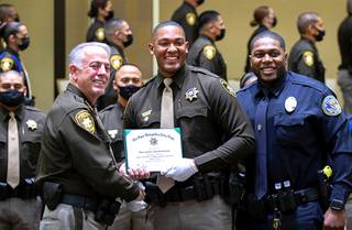 Shea Garland-Stewart, center, poses with Sheriff Joe Lombardo, left, and Charles Jackson Jr., a City of Henderson corrections officer, during a graduation ceremony for Metro Police correction officers at the Orleans Thursday, May 27, 2021. Garland-Stewart and Jackson both played basketball for Valley when they were in high school.
