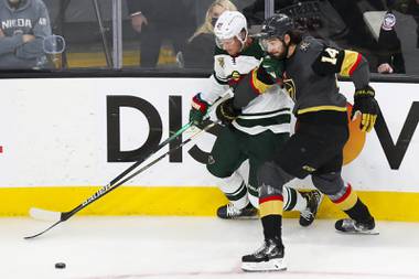 Vegas Golden Knights defenseman Nicolas Hague (14) and Minnesota Wild center Nick Bjugstad (27) vie for the puck during the second period of Game 7 of an NHL hockey Stanley Cup first-round playoff series at T-Mobile Arena Friday, May 28, 2021.