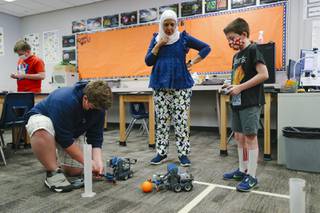 From left, paraprofessional substitute Nermine Gadelrab watches as Quinlin Handley, 14, and Bryant Seegmiller, 11, use VEX IQ Clawbots in robotics club during summer session at Thurman White Academy of the Performing Arts in Henderson Wednesday, June 9, 2021.