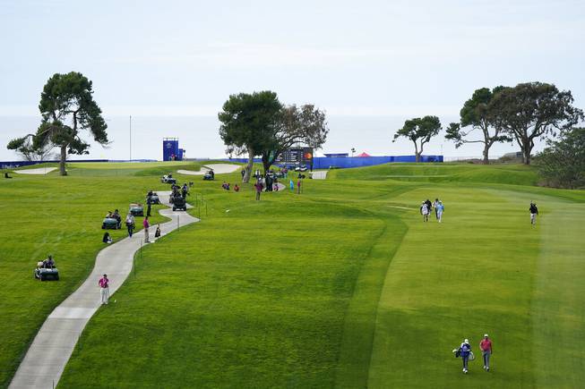In this Jan. 31, 2021, file photo, Jon Rahm, lower right, of Spain, walks down with 13th fairway with his caddie, Adam Hayes, on the South Course during the final round of the Farmers Insurance Open golf tournament at Torrey Pines in San Diego.