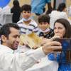 Iraqi native Kofades, who didn't disclose his last name, takes a selfie with his family at a ceremony to celebrate World Refugee Day and to honor newly naturalized Las Vegans at East Las Vegas Library Thursday, June 17, 2021.
