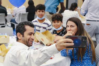 Iraqi native Kofades, who didn’t disclose his last name, takes a selfie with his family at a ceremony to celebrate World Refugee Day and to honor newly naturalized Las Vegans at East Las Vegas Library Thursday, June 17, 2021.
