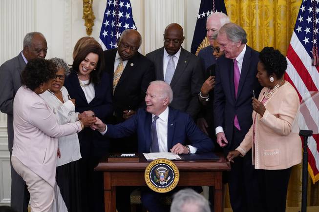 In this June 17, 2021, file photo, President Joe Biden hands a pen to Rep. Barbara Lee, D-Calif., after signing the Juneteenth National Independence Day Act, in the East Room of the White House in Washington. From left, Rep. Barbara Lee, D-Calif, Rep. Danny Davis, D-Ill., Opal Lee, Sen. Tina Smith, D-Minn., obscured, Vice President Kamala Harris, House Majority Whip James Clyburn of S.C., Sen. Raphael Warnock, D-Ga., Sen. John Cornyn, R-Texas, Rep. Joyce Beatty, D-Ohio, obscured, Sen. Ed Markey, D-Mass., and Rep. Sheila Jackson Lee, D-Texas.