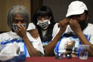 Family members of Byron Williams, from left, sister Cheryl Lewis, niece Marcia Wells and sister Gwendolyn Lewis comfort each other during a news conference, Thursday, July 15, 2021, in Las Vegas. The family of 50-year-old Byron Williams, whose death in Las Vegas police custody after a bicycle chase in 2019 was ruled a homicide, is suing the city and four officers they accuse of wrongful death and civil rights violations. (AP Photo/John Locher)
