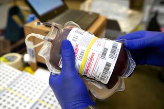 A phlebotomist holds a pint of donated blood during an American Red Cross blood drive at Centennial Hills Library Friday, July 16, 2021.