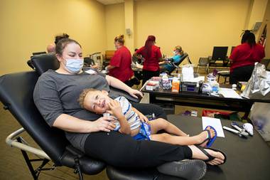 Markus Hickman, 3, sits on his mother’s lap as Stephanie Hickman waits to donate blood Friday, July 16, 2021, at an American Red Cross blood drive at Centennial Hills Library. The Red Cross says there is a blood shortage across the nation and is urging donors to give.