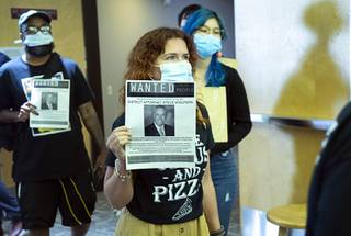 Activists hold up wanted fliers for Clark County District Attorney Steve Wolfson as they leave a Racial Justice and the Justice System panel discussion at the College of Southern Nevada, Cheyenne Campus, Saturday, July 17, 2021. The event was hosted by the NAACP of Las Vegas and sponsored by the LVMPD Foundation.
