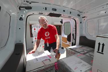 American Red Cross volunteer driver Jerry Runyon unloads boxes from a van at the Red Cross offices after a delivery Wednesday, July 21, 2021.