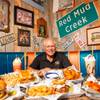 Sickies Garage Burgers & Brew owner Kenneth Harris poses for a photo with an array of food from his restaurant Thursday, July 22, 2021.