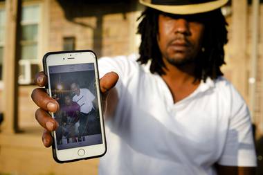 Dion Green holds a cellphone showing a picture of himself and his father, Derrick Fudge, who was killed Sunday, Aug. 4, 2019, in a mass shooting in Dayton, Ohio. Green just wanted to have some fun with his family in downtown Dayton after what had been a tough couple of months in the aftermath of damaging tornadoes. But his Saturday night out ended tragically, with his father dying in his arms, his eyes looking into his as he took his final breath. 