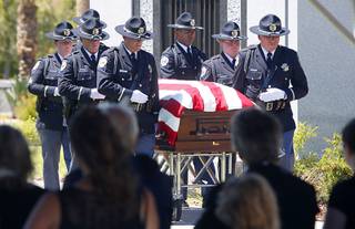 Pallbearers carry the casket of Nevada Highway Patrol Trooper Micah May during an interment ceremony at Palm Eastern Mortuary & Cemetery Friday, Aug. 6, 2021. May, 46, died July 29, two days after he was struck by a car during a pursuit on Interstate-15 in Las Vegas.