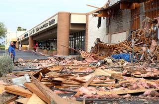 Jaime Martinez, left, president of La Bonita Grocery, looks over damage after a La Bonita supermarket storefront collapsed Friday morning, Aug. 13, 2021. Authorities say four people were treated for unspecified minor injuries after the storefront collapse at the supermarket.
