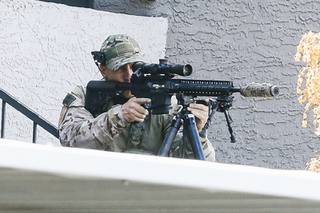 A SWAT police officer takes up a sniper position during a barricade situation at Sunrise Springs Apartments off E. Twain and Boulder Highway Monday, Aug. 23, 2021.