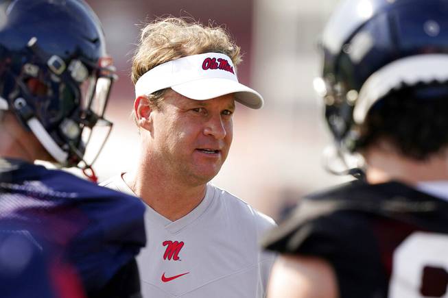 In this Aug. 9, 2021, file photo, Mississippi coach Lane Kiffin speaks with his players during NCAA college football practice in Oxford, Miss., Monday,. Mississippi takes on Louisville in Monday night’s Chick-Fil-A Kickoff game that wraps up college football’s first full weekend. 
