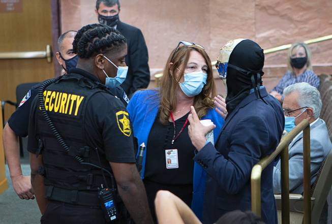 Clark County Commission Chairwoman Marilyn Kirkpatrick, center, talks to a man who had refused to keep his mask on during a commission meeting at the Clark County Government Center Tuesday, Sept. 21, 2021.