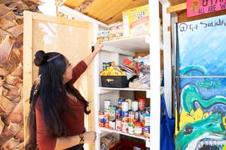 Victoria Flores, organizer of The Solidarity Fridge, shows some of the dry food and canned goods  donated by members of the community to the pantry. Sept. 21, 2021.