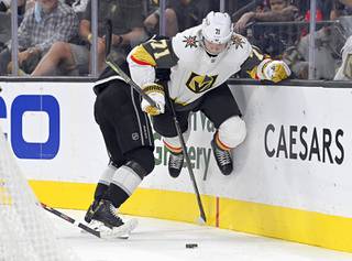 Vegas Golden Knights center William Karlsson (71) is held by Los Angeles Kings defenseman Kale Clague (58) during the second period of an NHL preseason hockey game Friday, Oct. 1, 2021, in Las Vegas.