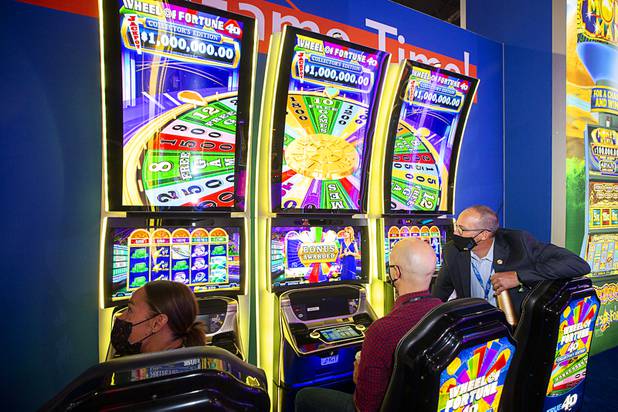 Attendees try out IGTs Wheel of Fortune 4D Collectors Edition slot machines during the Global Gaming Expo (G2E) at the Sands Expo Center Tuesday, Oct. 5, 2021. The machines have 4D technology built into the seats.