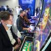 Levi Elliott, left, a technician with Longhorn Amusement, tries out a new slot machine game during the Global Gaming Expo (G2E) at the Sands Expo Center Tuesday, Oct. 5, 2021.