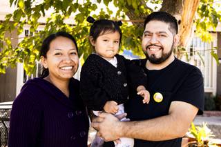 Ronal Portillo poses for a photo with his wife Marisela Duran-Cerro and their 2-year old daughter Arlette outside their home Wednesday, Oct. 13, 2021.  Portillo, who was laid off in March 2020 from his buffet cook position at Fiesta Rancho casino, has since struggled to find work and make ends meet. YASMINA CHAVEZ
