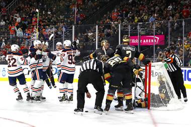 Edmonton Oilers celebrate a goal by left wing Zach Hyman (18) as Vegas Golden Knights center William Karlsson (71) sits in the net during the first period of an NHL hockey game Friday, Oct. 22, 2021, in Las Vegas. (AP Photo/Steve Marcus)