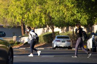 Students use the crosswalk after being dropped off at Becker Middle School Thursday, Oct. 14, 2021.