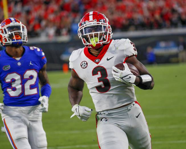 Georgia Bulldogs running back Zamir White (3) eludes Florida Gators safety Mordecai McDaniel (32) on this 4th quarter touchdown run during the second half of the annual NCCA Georgia vs Florida game at TIAA Bank Field in Jacksonville, Oct. 30, 2021. Georgia won 34-7. 