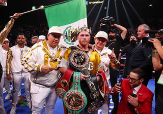 Undisputed super middleweight champion Canelo Alvarez, of Mexico, poses with title belts after defeating Caleb Plant in a super middleweight title unification fight Saturday, Nov. 6, 2021, in Las Vegas.