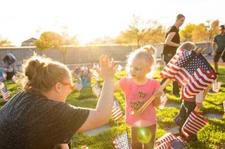 Volunteers, including veterans, first responders, and military service members, gather at the Southern Nevada Veterans Memorial Cemetery in Boulder City on Wednesday Nov. 10, 2021, to place flags on the gravestones ahead of Veteran's Day.