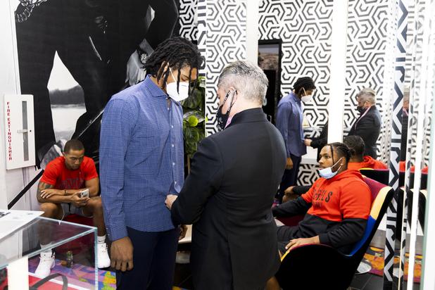 UNLV football players Tre Caine, left, and Farrell Hester, right, stand by as Ricci Lopez, Maceoos Retail and Creative Director, makes adjustments to teammate Noah Beans shirt during a suit fitting at Aria Hotel & Casino Thursday, Nov. 11, 2021. Through a partnership with Blueprint sports, former UNLV kicker Michael Chudd is sponsoring a program (now possible under the new NCAA NIL rules) that will give each graduating member of the UNLV football team a custom-made suit from Maceeo in exchange for social media sharing.