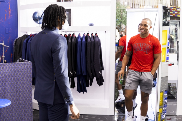UNLV football player Tre Caine, right, reacts to teammate Noah Beans, left, fitted garment during a suit fitting at Maceoo inside Aria Hotel & Casino, Thursday, Nov. 11, 2021. Through a partnership with Blueprint sports, former UNLV kicker Michael Chudd is sponsoring a program (now possible under the new NCAA NIL rules) that will give each graduating member of the UNLV football team a custom-made suit from Maceeo in exchange for social media sharing.