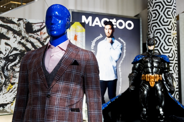 A Maceoo ad is seen behind a suited mannequin and a batman sculpture at store inside Aria Hotel & Casino, Thursday, Nov. 11, 2021. Through a partnership with Blueprint sports, former UNLV kicker Michael Chudd is sponsoring a program (now possible under the new NCAA NIL rules) that will give each graduating member of the UNLV football team a custom-made suit from Maceeo in exchange for social media sharing.