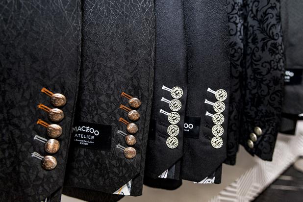 An array of black patterned suit jackets are seen on display at Maceoo inside Aria Hotel & Casino, Thursday, Nov. 11, 2021. Through a partnership with Blueprint sports, former UNLV kicker Michael Chudd is sponsoring a program (now possible under the new NCAA NIL rules) that will give each graduating member of the UNLV football team a custom-made suit from Maceeo in exchange for social media sharing.