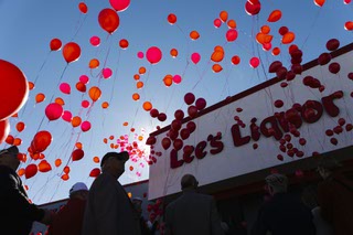Balloons are released during a vigil, Friday, Nov. 26, 2021, for Kenny Lee, CEO of Lees Discount Liquor, who was killed in a car accident a week ago.
