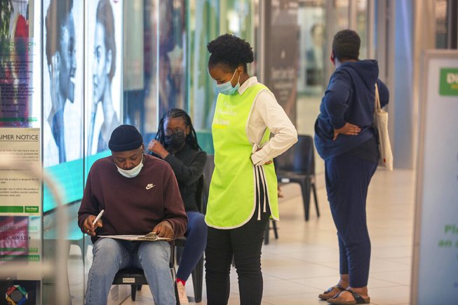 People wait to get vaccinated at a shopping mall, in Johannesburg, South Africa, Friday Nov. 26, 2021. 