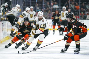 Vegas Golden Knights’ Max Pacioretty, center, moves the puck under pressure by Anaheim Ducks’ Jamie Drysdale, right, and Hampus Lindholm during the first period of an NHL hockey game Wednesday, Dec. 1, 2021, in Anaheim, Calif. 