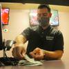 A clerk counts money at the sports book at Freehold Raceway on Oct. 24, 2020, in Freehold, N.J. With advertisements for sports betting blanketing the airwaves, some in the industry and their pro sports and technology partners are starting to ask how much is too much? 